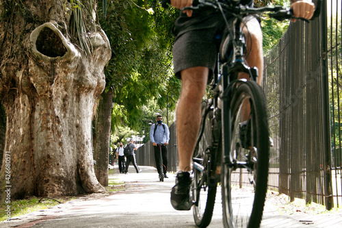 Pessoa andando de bicicleta e scooter elétrico na ciclovia em Curitiba. photo