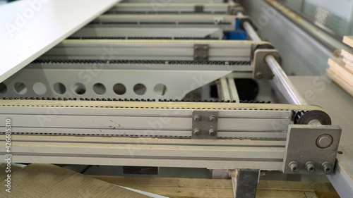 Production line on furniture factory. Production of furniture edging detail. Plywood on a machine in the furniture industry.