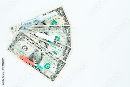 Dropper with dollars on white background. Concept of treatment and health.