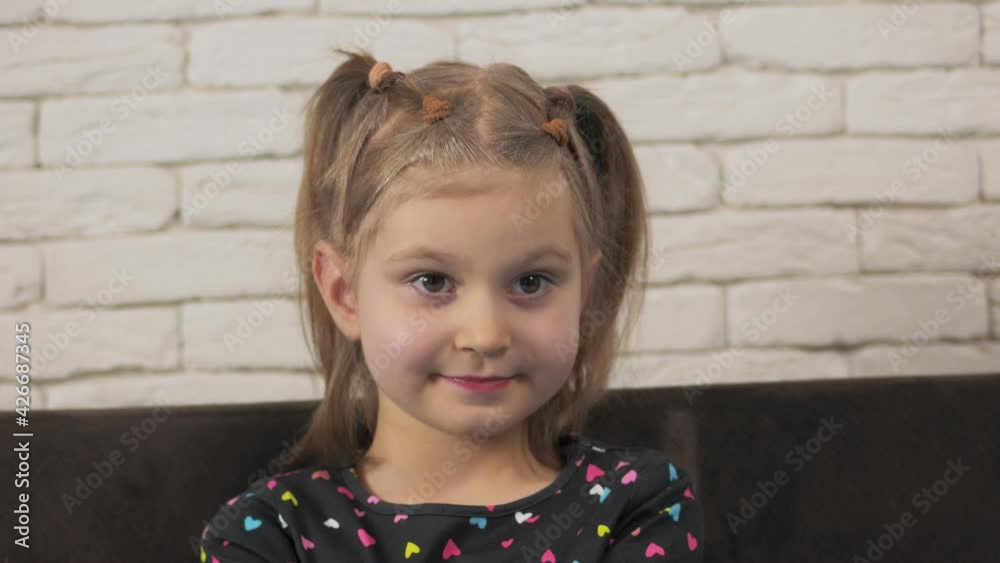 Close-up portrait of a little girl, carefully looking at the TV screen or the interlocutor. Close-up portrait of a little girl, carefully looking at the TV screen or the interlocutor.