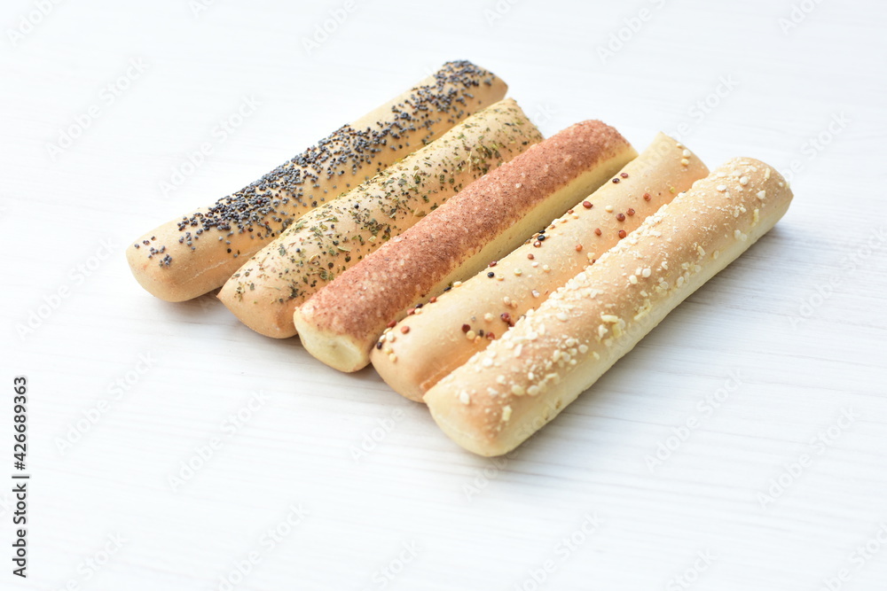 Puff pastry cheese stick, decorated with Parmesan cheese on white wooden background