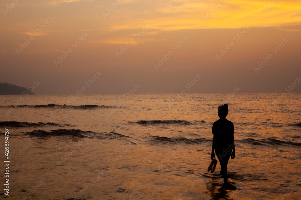 A silhouette with an Indian sunset over the water
