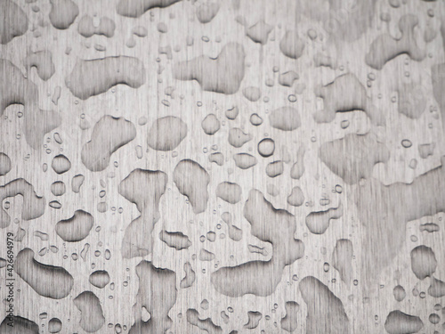 Raindrops on a gray rough metal surface