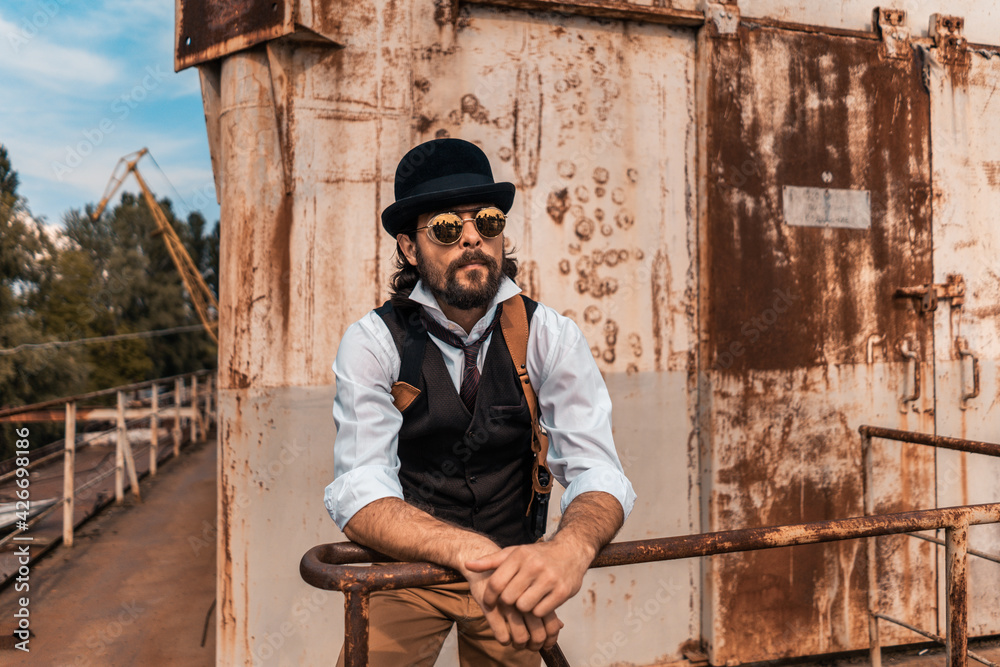 Steampunk. A hero on a river barge surrounded by steel mechanisms. A man with a weapon. Steampunk. A hero on a river barge surrounded by steel mechanisms. A man with a weapon.