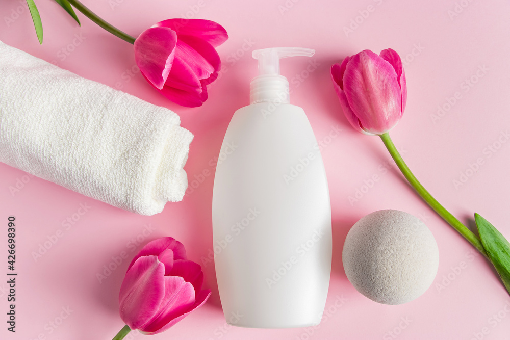 Spa skin care products on a pink background. Natural cosmetics and red tulips. Spa skin care products on a pink background. Natural cosmetics and red tulips.