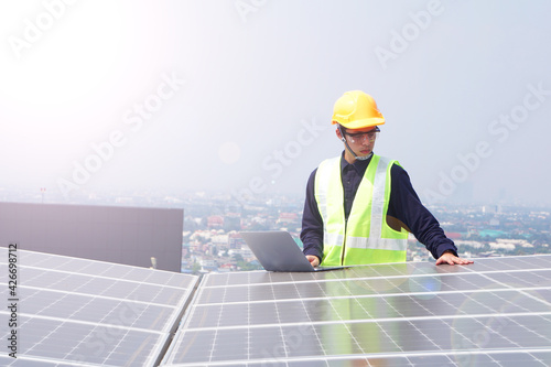 Asian engineer for solar panel inspection roof construction. Engineer worker installing solar panels outdoors