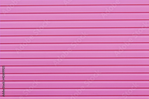 The wall of the house is finished with pink siding