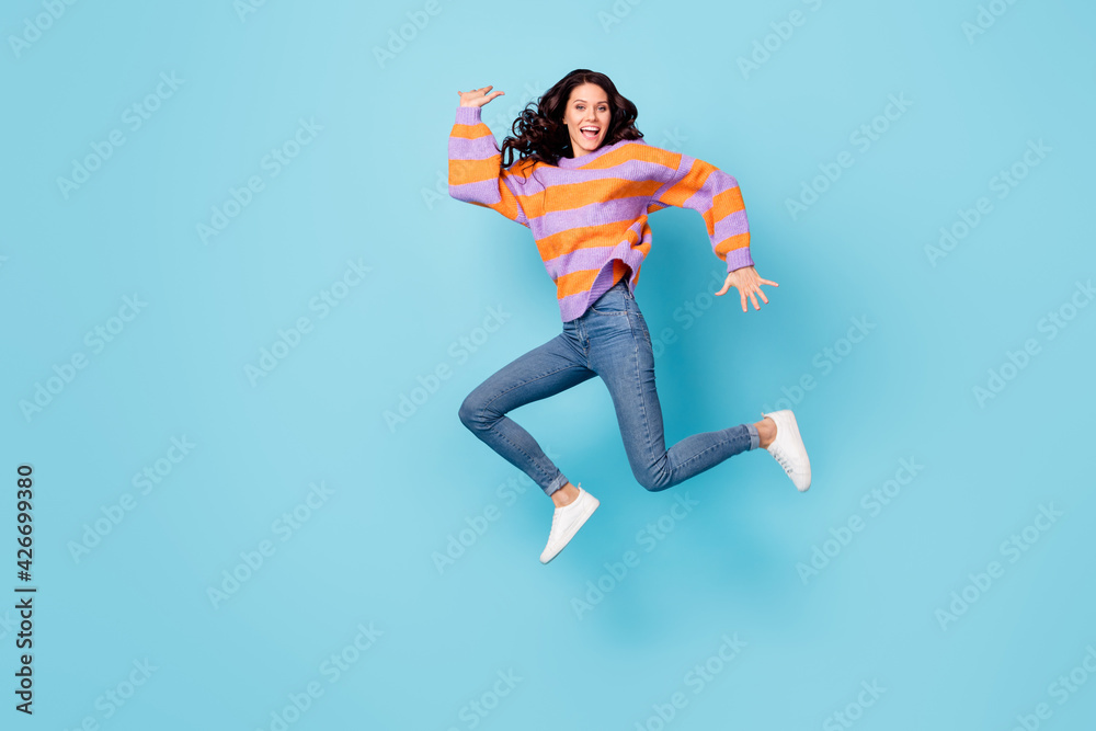 Full length body size view of pretty crazy cheerful wavy-haired girl jumping fooling having fun isolated over bright blue color background