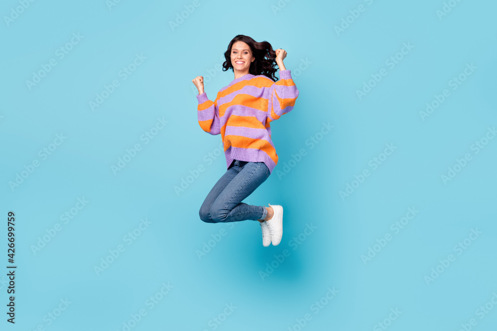 Full length body size view of lovely lucky cheerful wavy-haired girl jumping rejoicing having fun isolated over bright blue color background