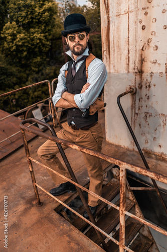 Steampunk. A hero on a river barge surrounded by steel mechanisms. A man with a weapon. photo