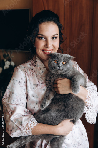 Morning of the bride with her pet. Girl with a gray cat.