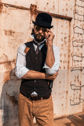 Steampunk. A hero on a river barge surrounded by steel mechanisms. A man with a weapon.