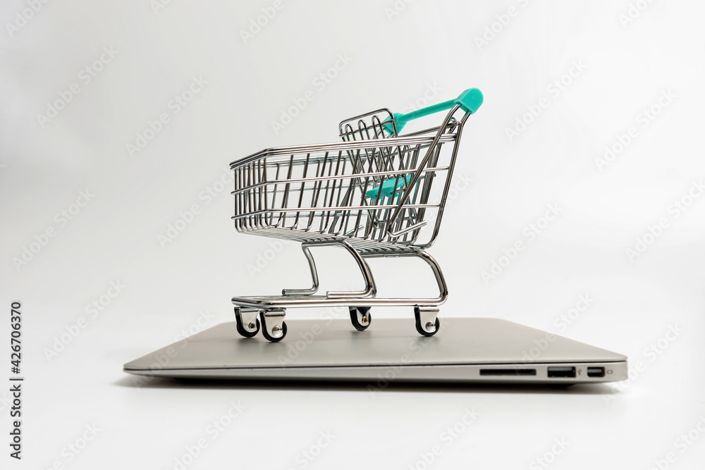 shopping cart on closed laptop isolated on white