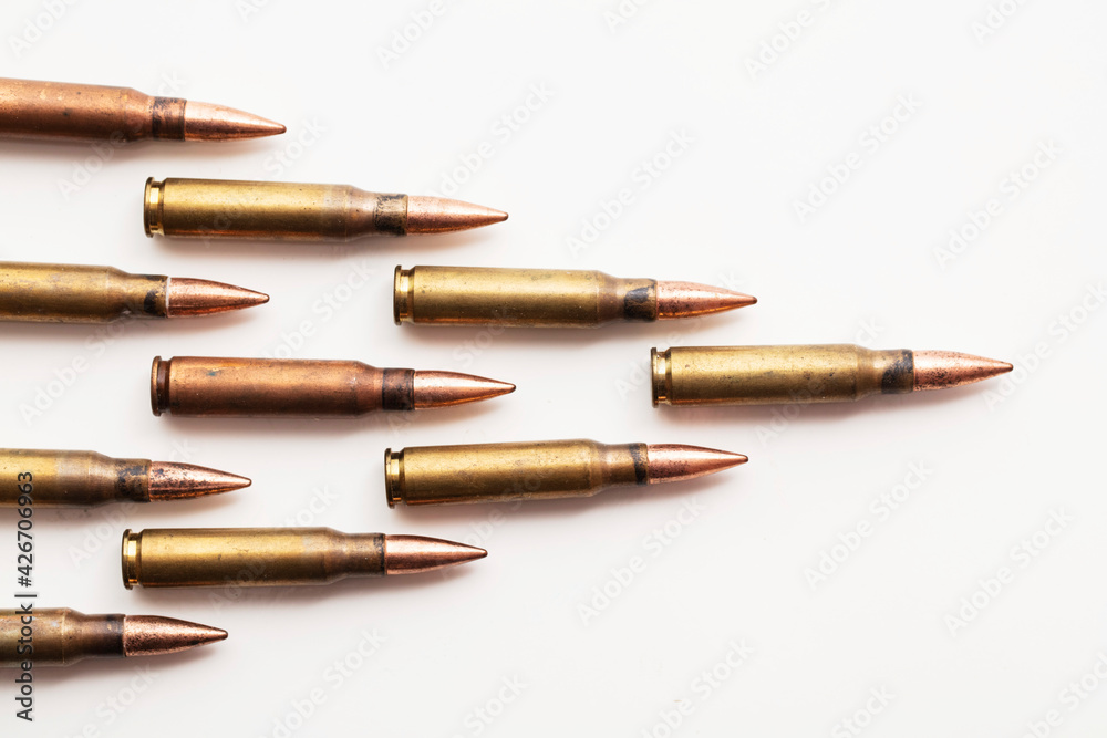 A group of bullet ammunition shells on a white background - obrazy, fototapety, plakaty 