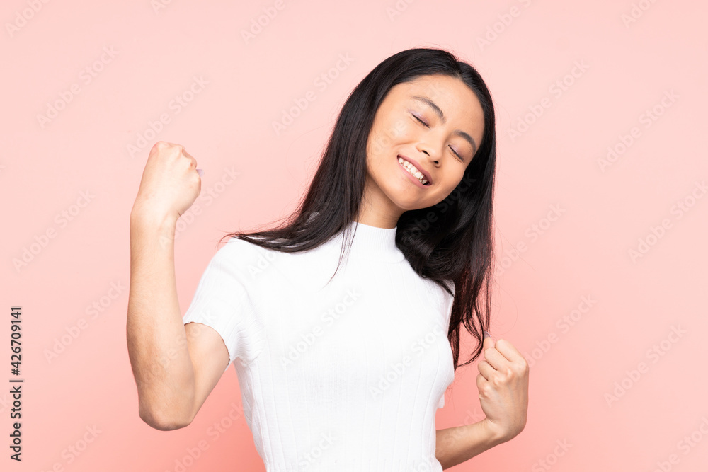 Teenager Chinese woman isolated on pink background celebrating a victory Teenager Chinese woman isolated on pink background celebrating a victory