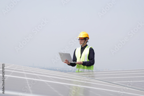 Asian engineer for solar panel inspection roof construction. Engineer worker installing solar panels outdoors
