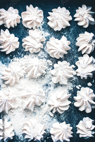 Meringue cookies on a blue background. Meringue background. Confectionery goodies