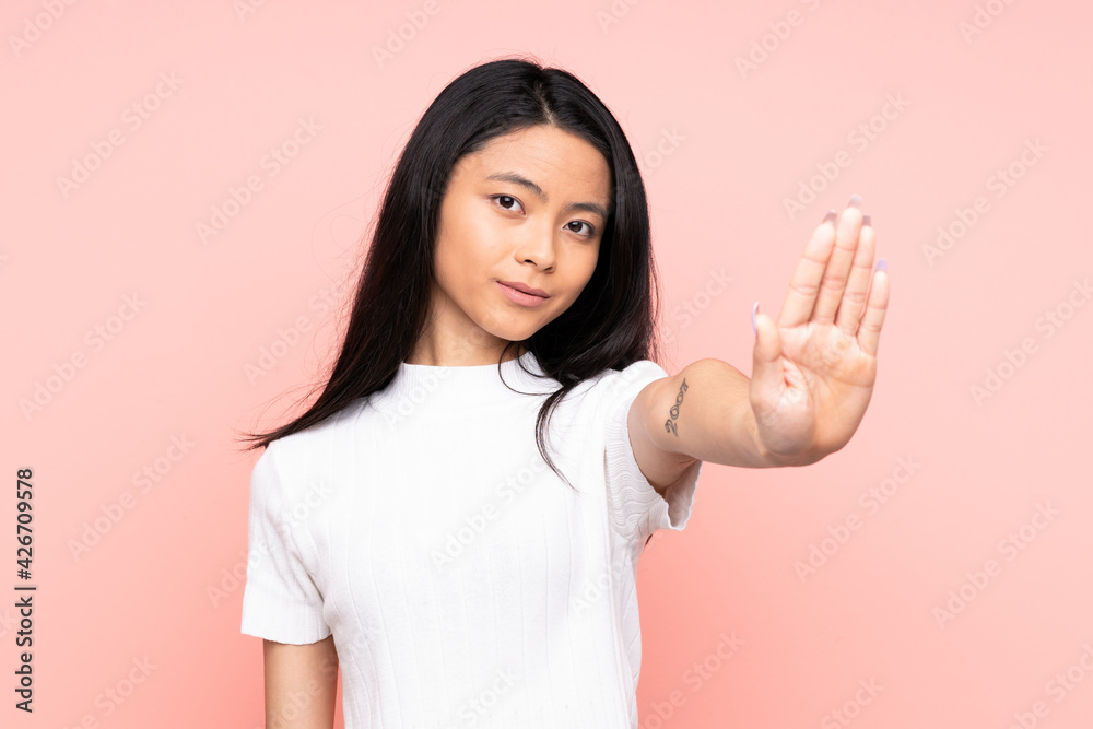 Teenager Chinese woman isolated on pink background making stop gesture Teenager Chinese woman isolated on pink background making stop gesture