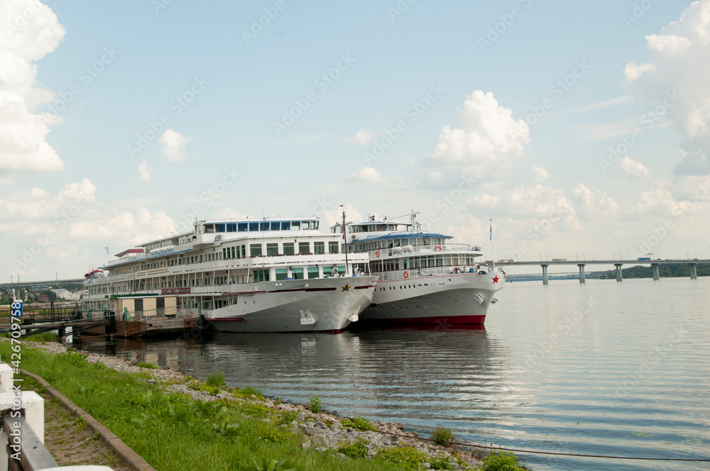 Panoramic view of the Volga and two pleasure boats at the pier. View from the embankment. Panoramic view of the Volga and two pleasure boats at the pier. View from the embankment.