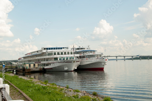 Panoramic view of the Volga and two pleasure boats at the pier. View from the embankment.