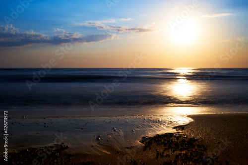 Sea sunset. Quiet calm sea. Sand beach.