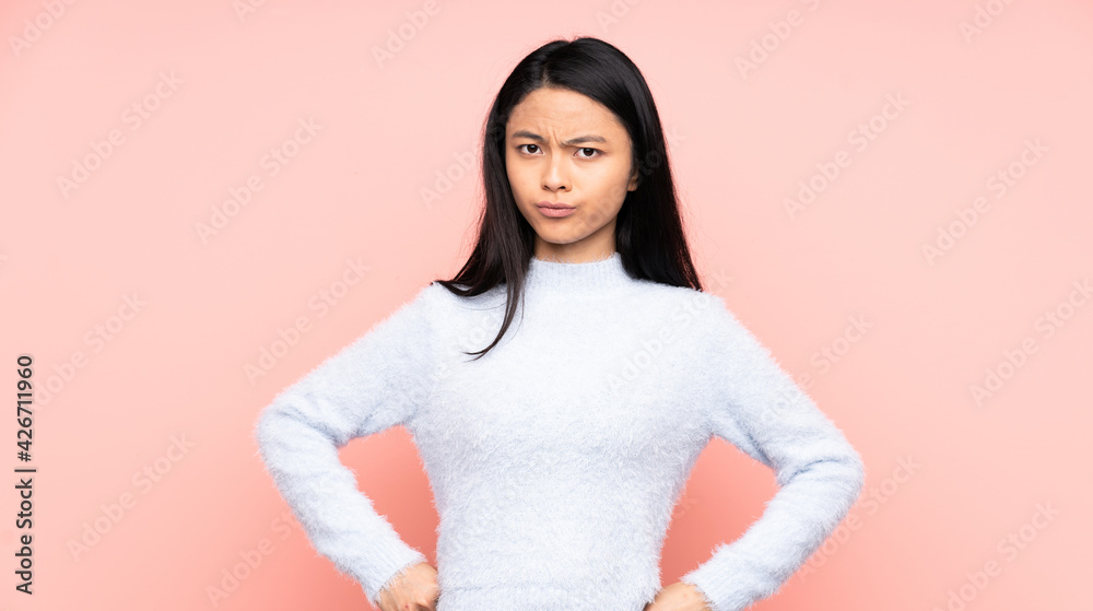Fototapeta premium Teenager Chinese woman isolated on pink background angry