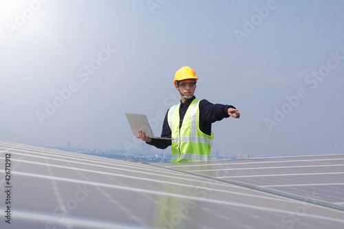 Asian engineer for solar panel inspection roof construction. Engineer worker installing solar panels outdoors
