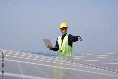 Asian engineer for solar panel inspection roof construction. Engineer worker installing solar panels outdoors