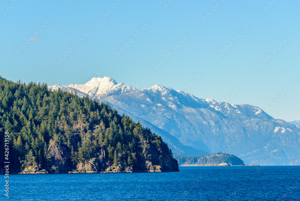 Fantastic view over ocean, snow mountain and rocks at Sechelt inlet in Vancouver, Canada.