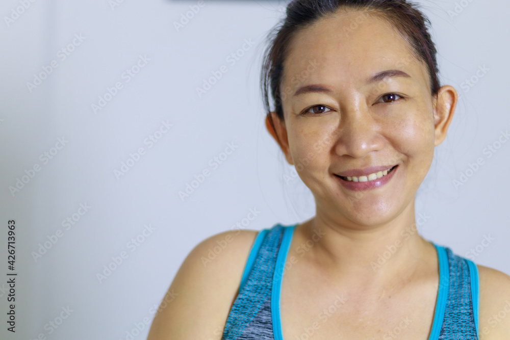 Portrait photo of beautiful adult (40 years old) Asian woman in blue color Sports Clothing for doing Home Workout in the room white background. Portrait photo of beautiful adult (40 years old) Asian woman in blue color Sports Clothing for doing Home Workout in the room white background.