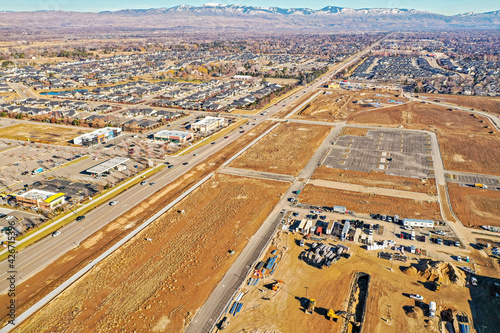 Drone photography of a large residential neighborhood, shopping center and new business construction site in Eagle, Idaho looking towards Boise, Idaho