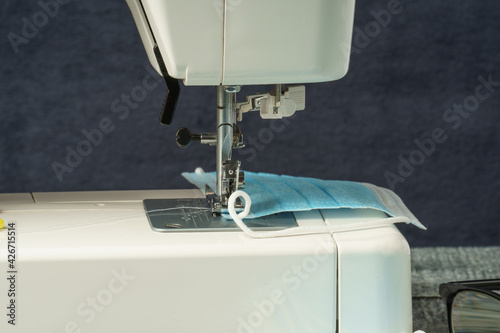 Fototapeta A sewing machine sewed a medical face mask during the dangerous coronavirus pandemic