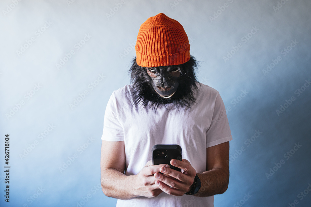 Male in a chimpanzee mask using his mobile phone - obrazy, fototapety, plakaty 