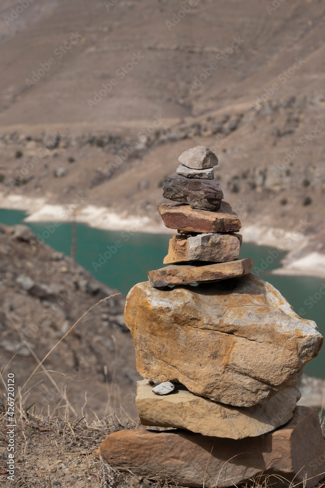 Balanced rocks in the mountains on the background of a blue lake