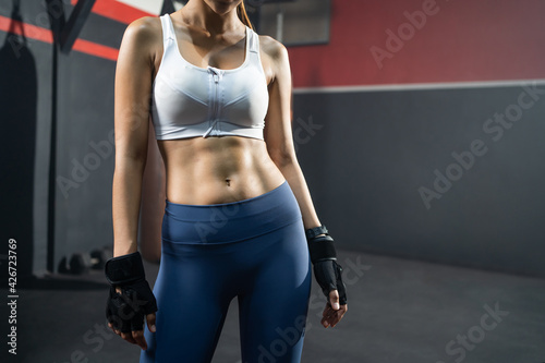 Close up shot at abdominal stomach muscle of adult women shot inside of fitness boxing gym. Healthy lifestyle for people who workout and training inside of the gym with copy space .