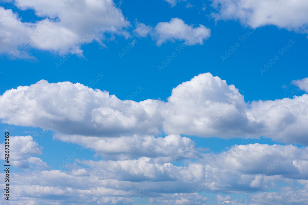 Many white fluffy clouds also known as cumulus on bright summer blue sky. Cloudscape, overcast. Many white fluffy clouds also known as cumulus on bright summer blue sky. Cloudscape, overcast.