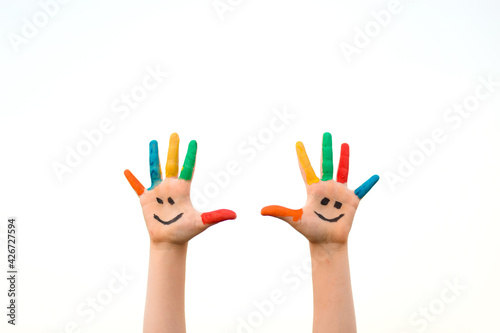 Banner view of children hands in colorful paint with funny smile face isolated on white background
