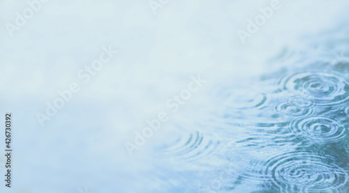 Background illustration with water puddle with rain drops. Pond with ripples from rain droplets