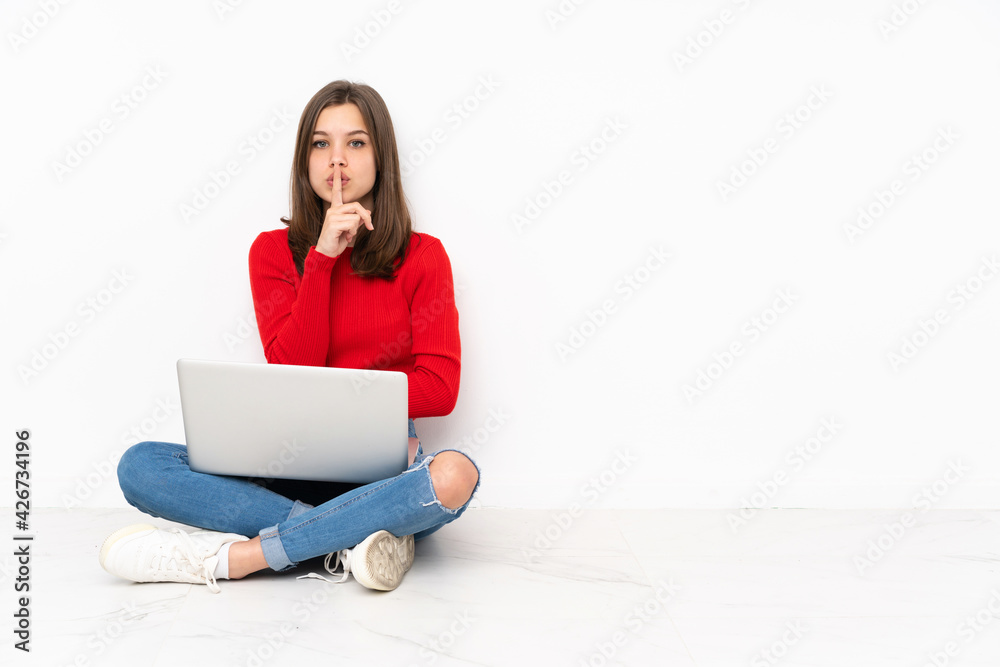 Tenaager girl working with pc isolated on white background showing a sign of silence gesture putting finger in mouth Tenaager girl working with pc isolated on white background showing a sign of silence gesture putting finger in mouth