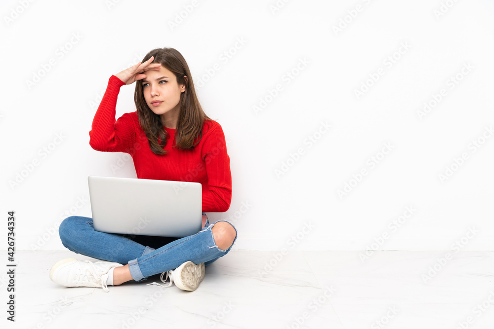 Tenaager girl working with pc isolated on white background looking far away with hand to look something