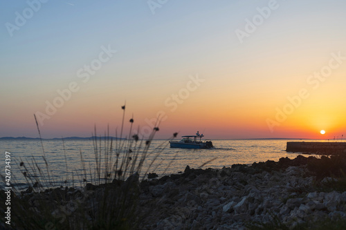 Small motor boat in the Adriatic sea near coastline at sunset on Vir island  Croatia