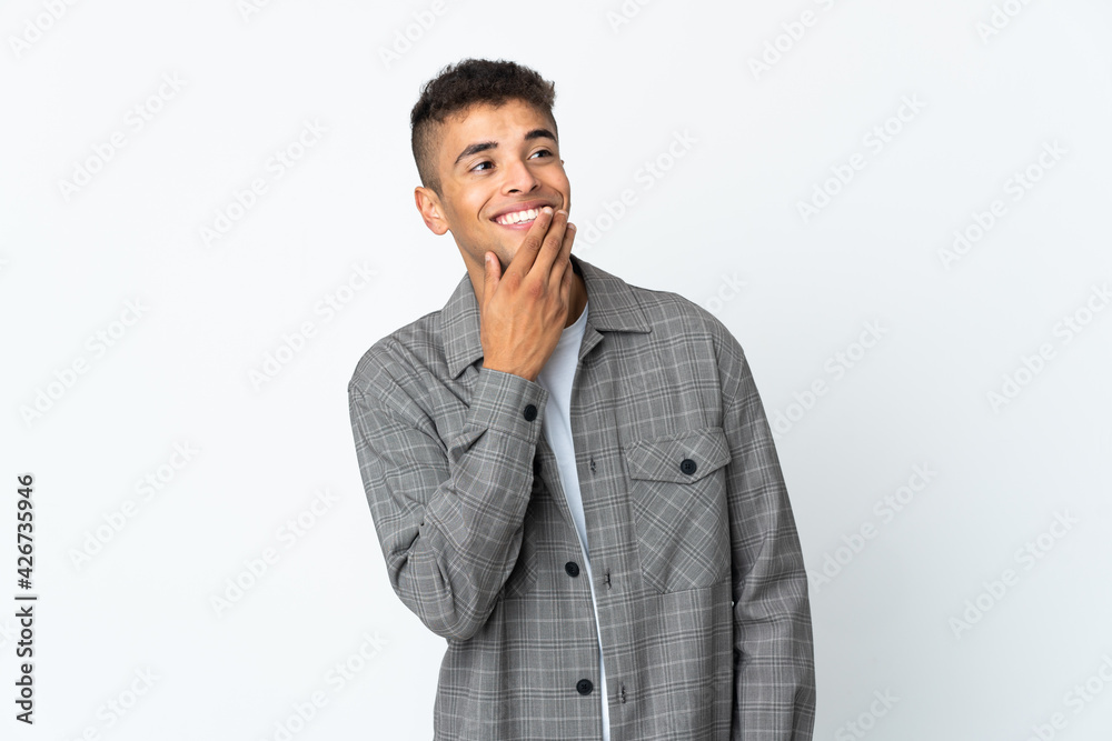 Young brazilian man isolated on white background looking up while smiling Young brazilian man isolated on white background looking up while smiling