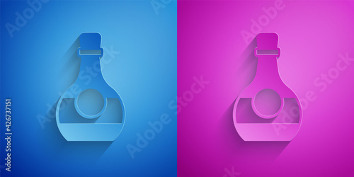 Paper cut Bottle of cognac or brandy icon isolated on blue and purple background. Paper art style. Vector