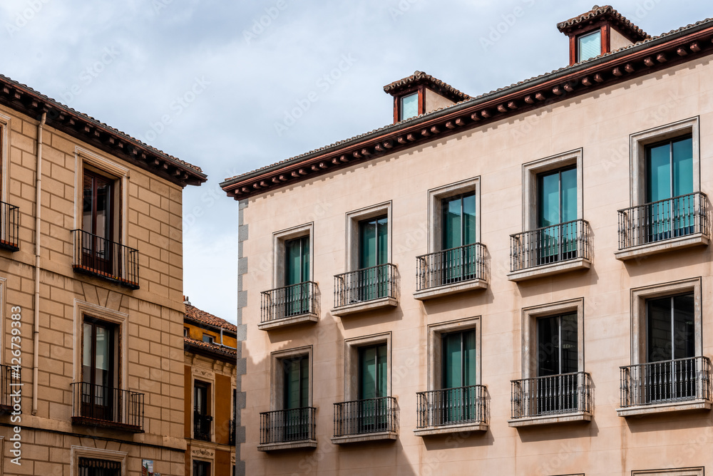 Old Traditional Residential Buildings in Central Madrid. Colorful Facades Against Cloudy Sky