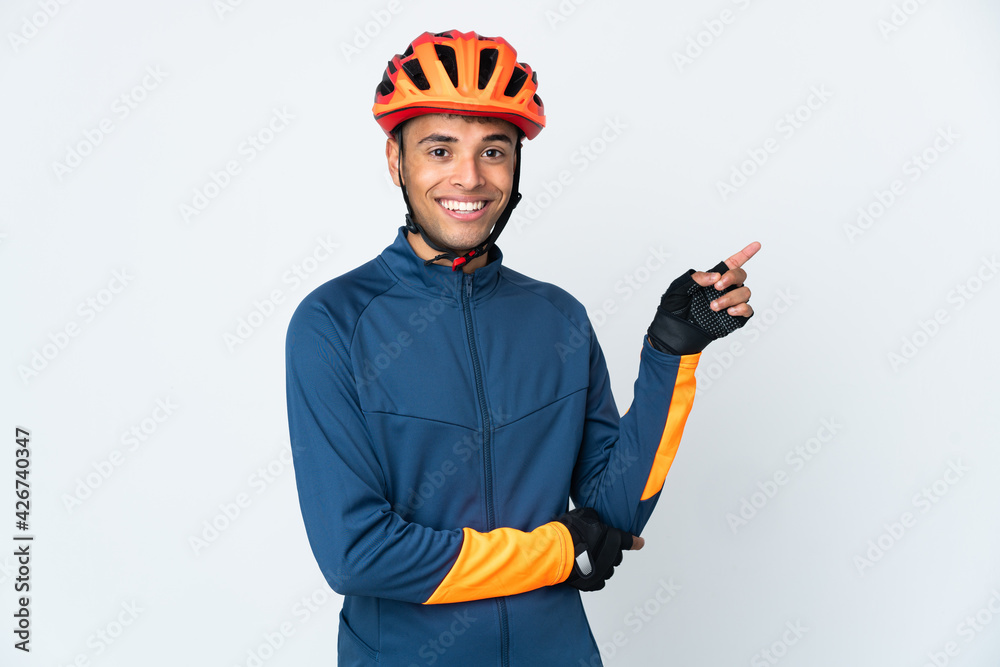 Young cyclist Brazilian man isolated on white background pointing finger to the side - obrazy, fototapety, plakaty 