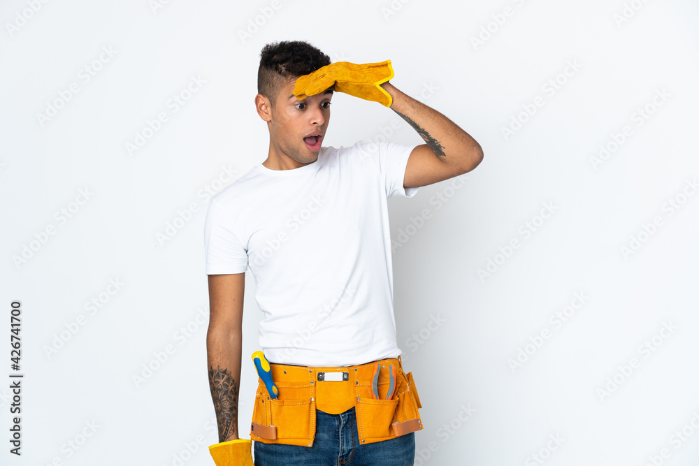 Young Brazilian electrician manipulated isolated on white background doing surprise gesture while looking to the side Young Brazilian electrician manipulated isolated on white background doing surprise gesture while looking to the side