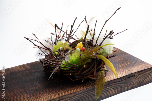 Easter themed nest made of sticks and feathers with cupcake and chocolate eggs photo