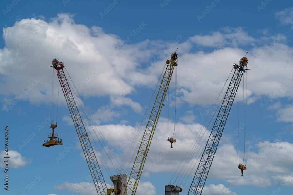 Three cranes with their arms up