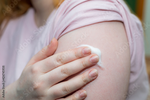 woman holds a fleece on her shoulder after being vaccinated against the coronavirus infection covid-19 during pandemic. photo