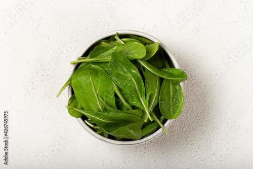 Arugula salad in a bowl on white background.